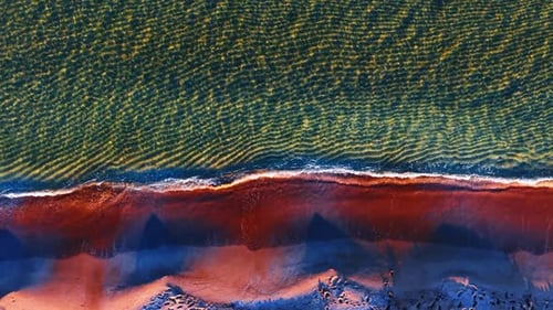 Paisaje acuático surcado que hace rodar olas hasta la costa.