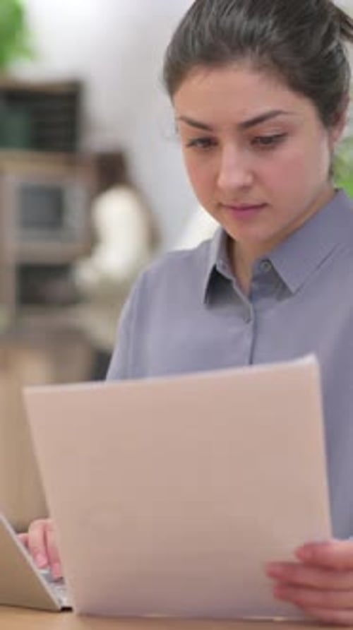 Focused Woman Works on Laptop in Modern Office