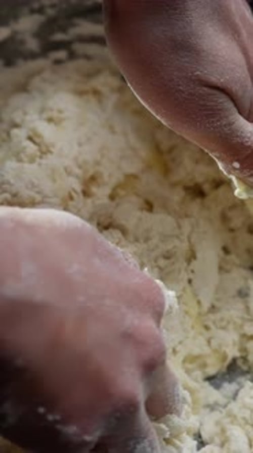 Hands Mixing Dough Ingredients in Silver Bowl
