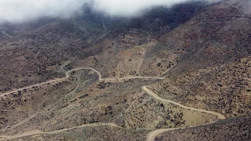 Remote mountain road contours arid hillside slopes in Argentina