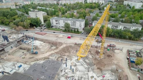 Tall Crane Operates Over Largescale Construction Site