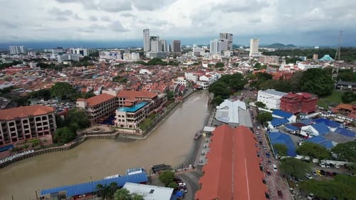 Aerial drone of a river in the city of Malacca Melaka Malaysia during a cloudy day track in shot
