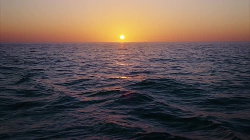 Ein wunderschöner und ruhiger Sonnenuntergang in Zeitlupe über ruhigen Meereswellen