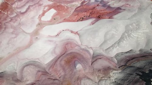 Aerial view tilting over rock formations in sunny Bentonite Hills, Utah, USA