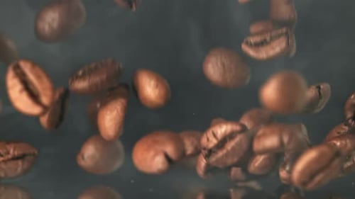 Superzeitlupen-Kaffeebohnen mit Rauch, gefilmt auf einer Hochgeschwindigkeitskamera mit 1000 Bildern pro Sekunde