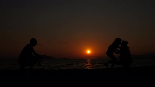 Family Silhouette on Beach at Sunset