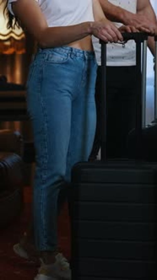 Couple Arriving at Hotel with Suitcase