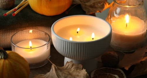 Candles and Pumpkins Glowing Warmly on Wooden Surface