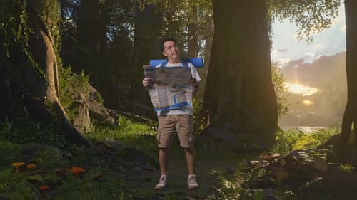 Asian Male Looking At The Map Then Looking Around While Exploring Nature