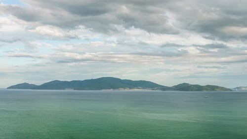 Wunderbare Wolken schweben über der Insel und dem Meer. Zeitraffer