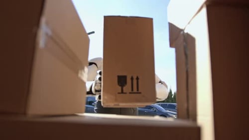 Close Up of Robot Putting Parcel Box to a Van Cyborg Courier Delivering Parcel Box to Recipient
