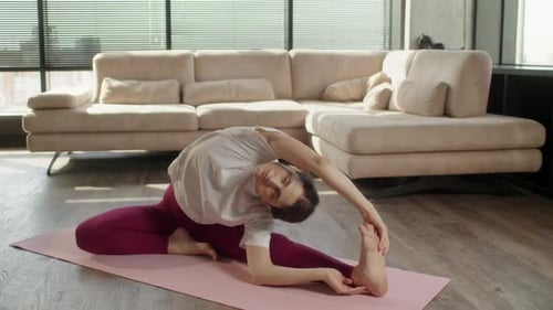 Woman Doing Yoga Stretches on Yoga Mat