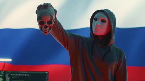Russischer Cyberkrimineller mit anonymer Maske und Kapuze, der einen Totenkopf hält