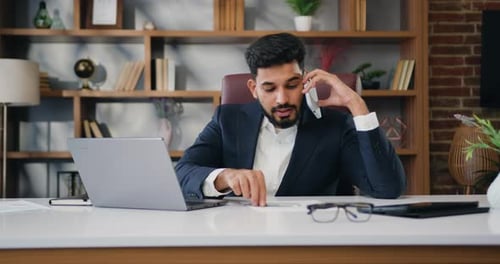 Young Adult Businessman on Cell Phone in Modern Office