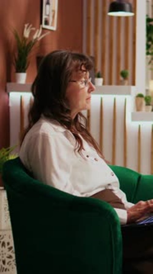Vertical Video Retired Client Browsing Laptop at Hotel