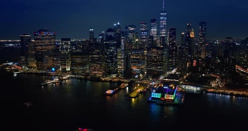 Approaching one of the multiple piers of New York with neon illumination from above the river