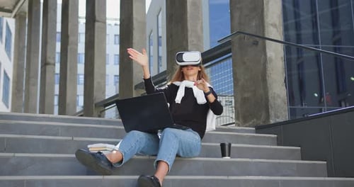 Woman Uses VR Headset Outdoors in City Setting