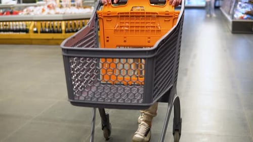 A Man Walking in Aisle with Shopping Trolely at Supermarket