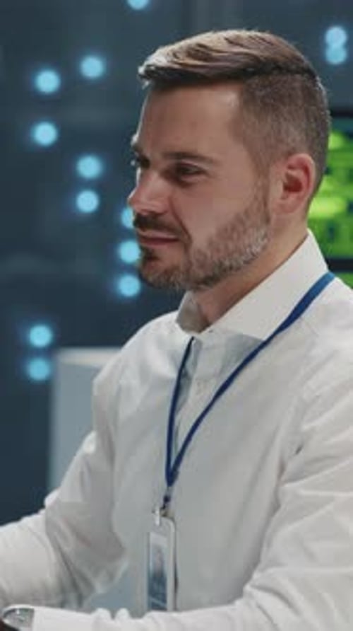 Man Working in Data Center, Looking at Monitors