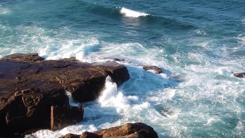 Ocean waves flooding on rocky shore, showing extreme force of ocean. Ultra Slow motion shot. Camera