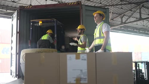 Blue collar workers are working at warehouse.