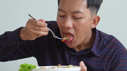 Man Enjoys a Tasty Salad Dish Indoors