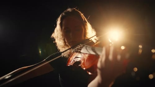 Violinist Performing Under Dramatic Stage Lighting
