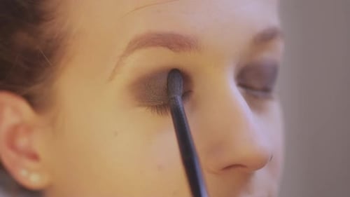 Woman Applying Eyeshadow with Makeup Brush, Close Up