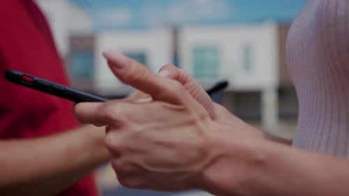 In a Busy Neighborhood a Man in a Red Shirt Shares a Phone