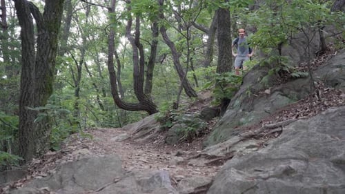 Man Hiker climbs down A Rocky Mountain With Narrow Path - Medium Shot, hiking concept low angle view