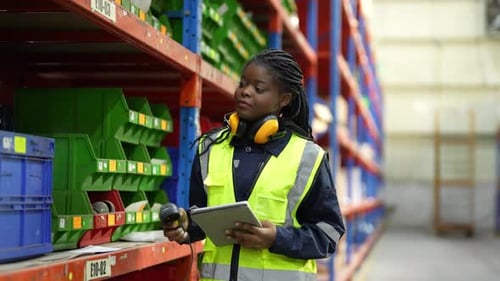 Warehouse Industrial and Logistics Companies. Dispatcher in uniform making inventory in storehouse.