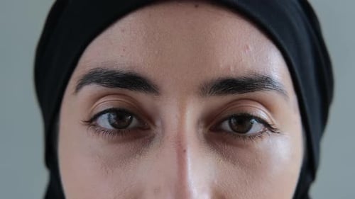 Nahaufnahme brauner Augen mit schwarzen Augenbrauen, die so tief in den Rahmen schauen, dass sie in Ihren
