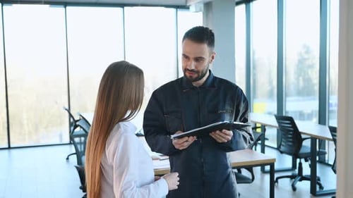 Sign this document. Man and woman employees are working in the office.