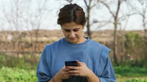 Woman Using Smart Phone Outdoors in Nature