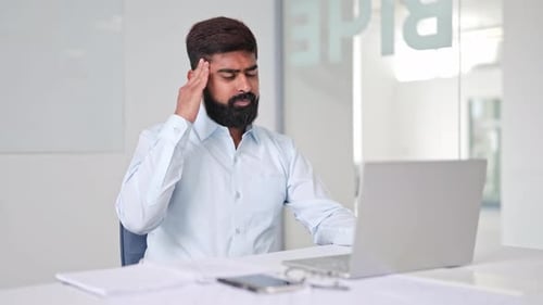 Man in Office Massaging Temples