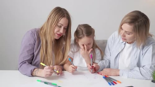 Adults and Child Drawing Together Indoors