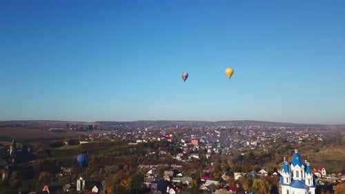 Aerial Shot of Town with Hot Air Balloons