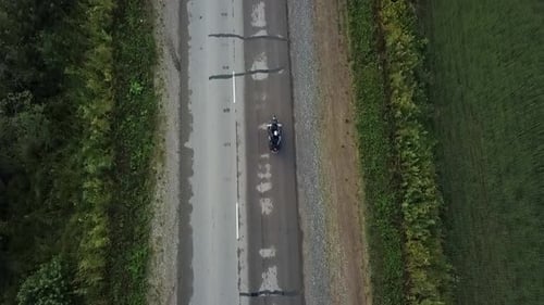 Motorcycle Rider Traveling on a Countryside Asphalt Road Aerial View Clip
