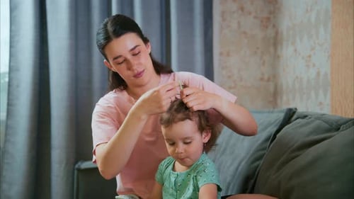 Loving Mother Styles Toddler's Hair at Home
