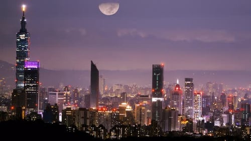 Charming Taipei night: the moon and dynamic cloud dance in the urban sky.