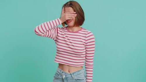 Jeune femme effrayée fermant les yeux avec la main montrant un geste d'arrêt confuse timide effrayée de regarder affreusement