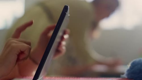Closeup School Student Using Digital Tablet in Classroom. Pupil Hands Searching Internet