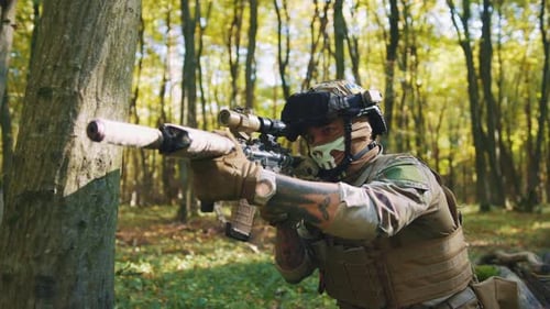 In Forest Soldier in Protective Camouflage Uniform with Weapons in the Sunlight Forest The Military
