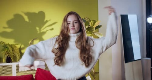Joyful Young Woman Dancing and Smiling Indoors
