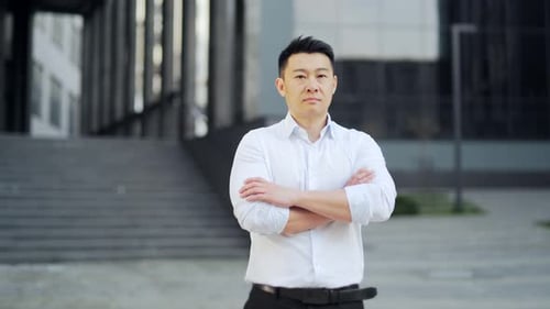 portrait confident asian business employee. outside Standing on urban background office building.