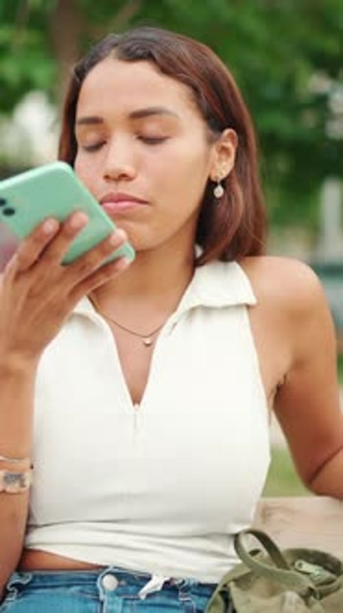 Woman Using Voice Messaging on Smartphone in Park