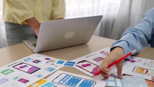 Mobile application UX and UI designers collaborating