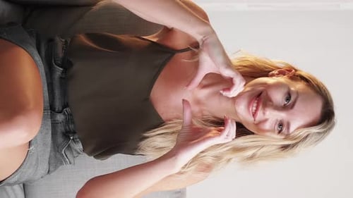 Blonde Woman Makes Heart Shape With Hands
