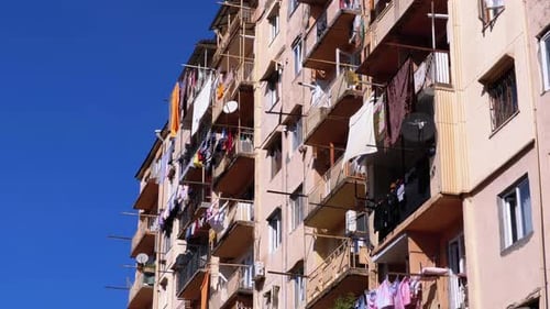 Drying Clothes on a Clothesline Between the Balconies on the Highrise Old House in a Poor Area of