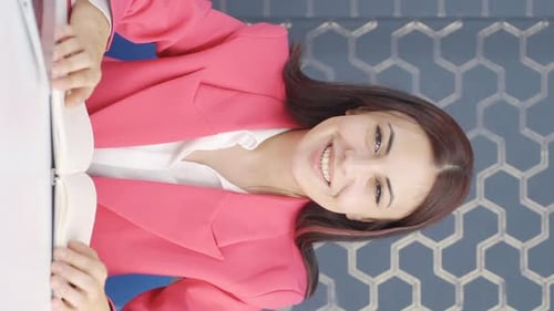Woman Talks and Waves at Her Desk